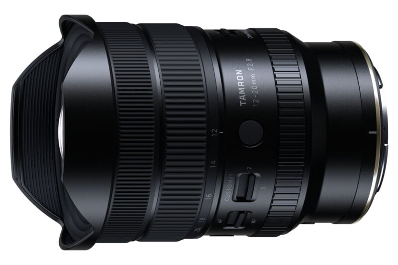 A close-up of a Tamron 12-20mm f/2.8 wide-angle camera lens, showing detailed textures, zoom and focus rings, switches, and branding on an isolated white background.