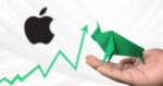 A hand holds a green origami bull in front of the Apple logo, with a green upward stock chart line in the background, symbolizing a bullish trend for Apple.