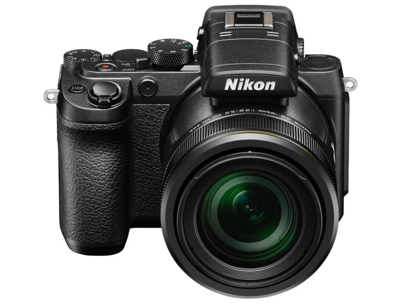 A Nikon digital camera with a large lens, viewed from the front, showing the brand name and various control dials on top.