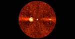 Orange-hued, grainy circular image of a star at the center with a glowing ring to the left and a smaller bright spot to the right, indicated by an arrow. The background is dark with scattered noise.