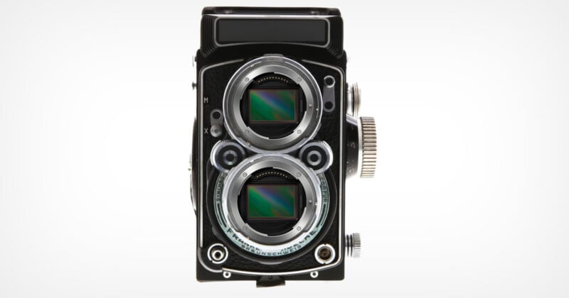A vintage twin-lens reflex camera with modern digital sensors visible in both lens openings, set against a plain white background.