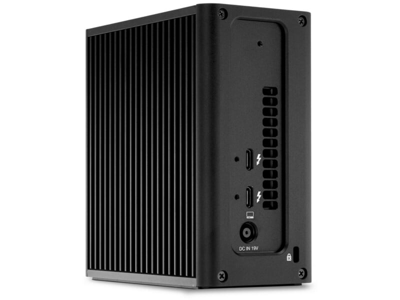 A black mini PC with vertical cooling fins on the sides, showing rear ports including two Thunderbolt ports, HDMI, USB-C, DC power input, and a small lock slot.