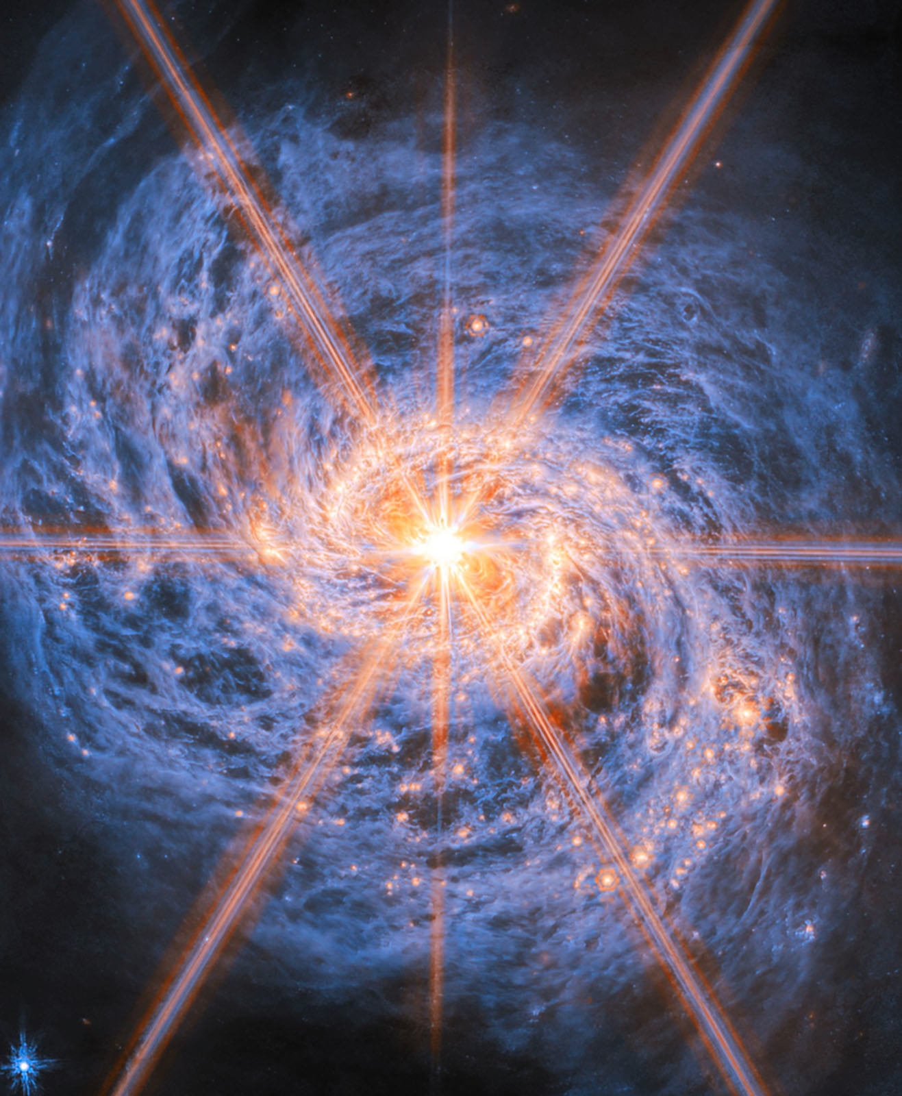 A bright star shines at the center of a swirling spiral galaxy with blue clouds and glowing orange light rays extending outward, set against a dark space background.