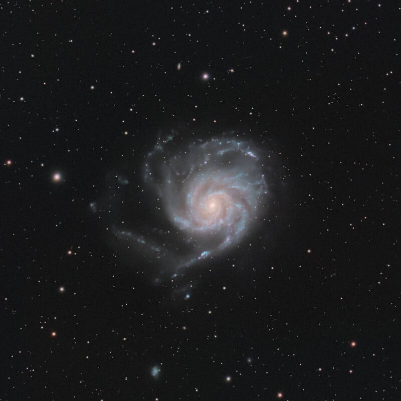 A spiral galaxy with bright, swirling arms and a glowing central core set against a dark, star-filled sky.