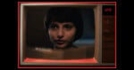A close-up of a young person with short dark hair appears on an old-fashioned television screen, which displays the channel as UHS. The TV has wood paneling and red lighting around the edges.