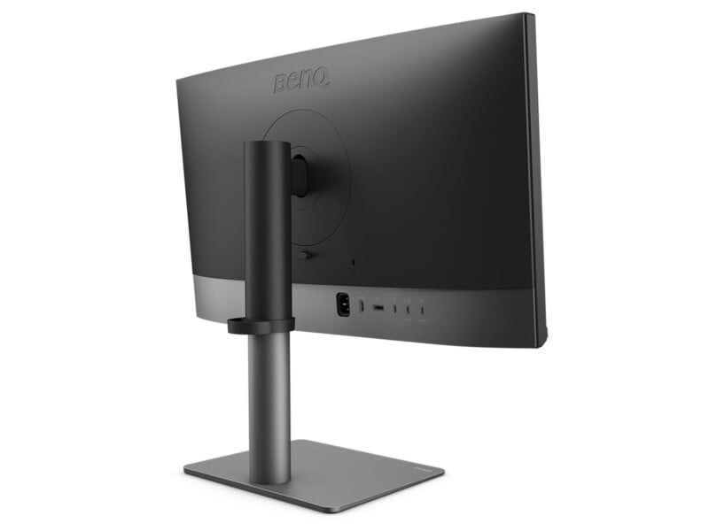 A black BenQ computer monitor shown from the back, mounted on a rectangular stand, with various ports visible along the lower back panel.