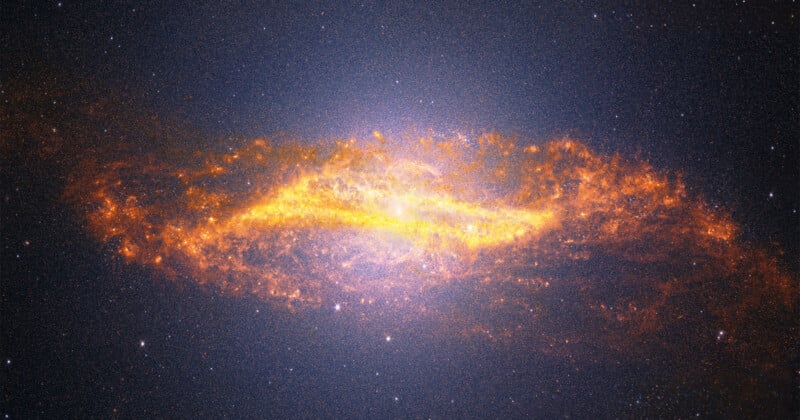 A bright, glowing spiral galaxy with fiery orange and yellow dust swirling around its center, set against a dark, star-filled space background.