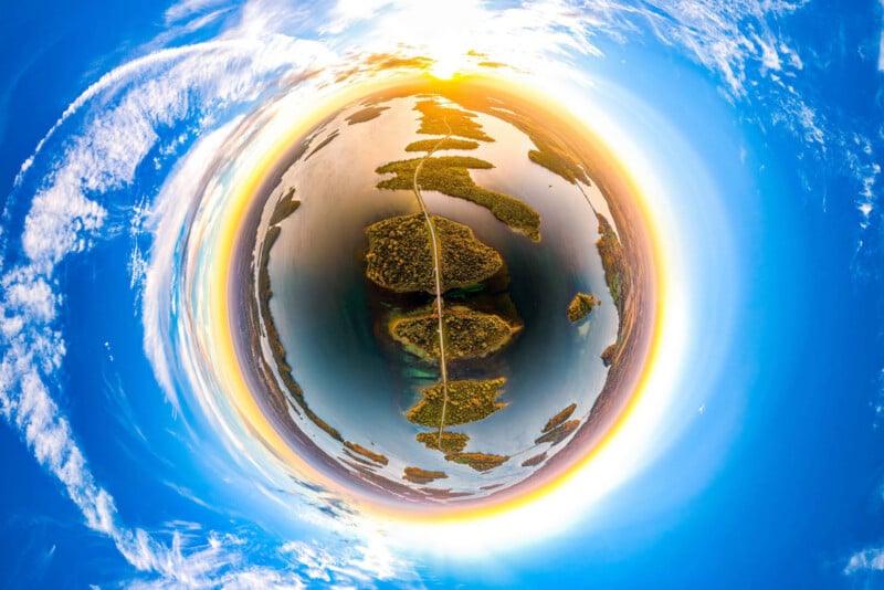 A 360-degree panoramic view of a road crossing a series of islands in a lake, captured with a tiny planet effect.