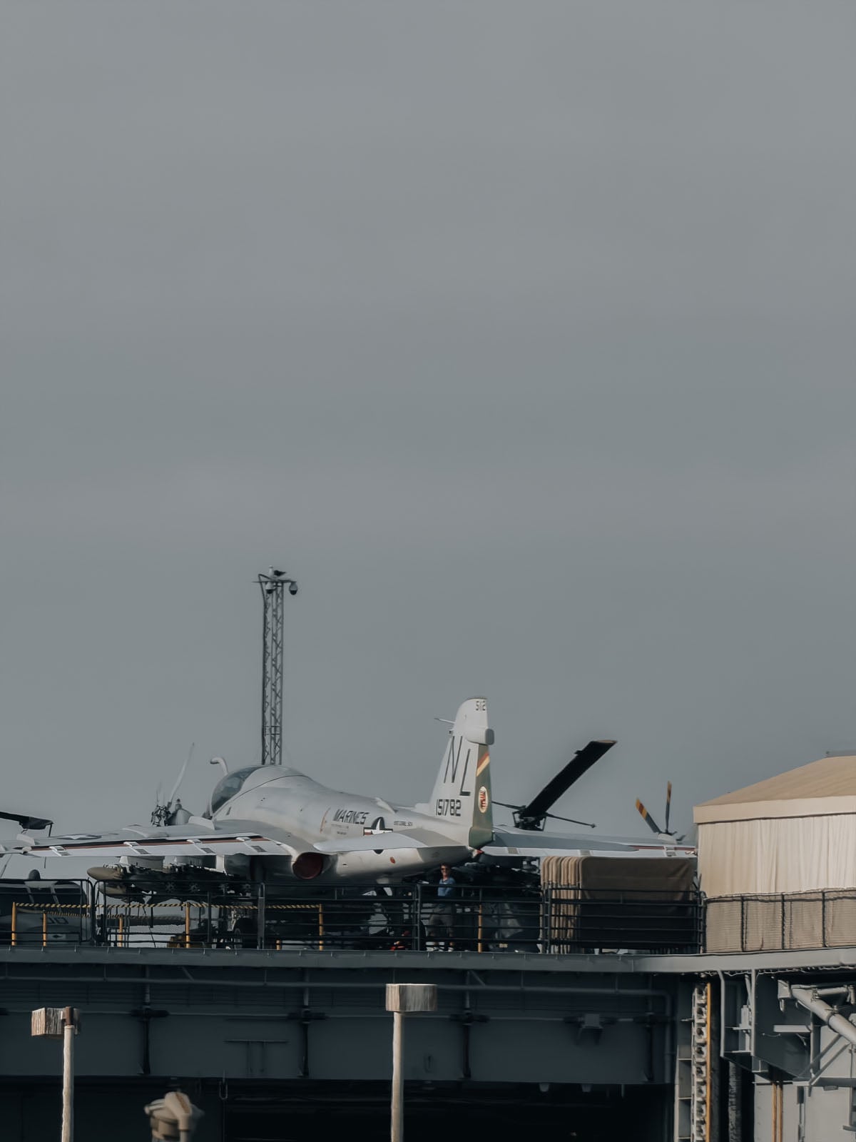 A Grumman A-6 Intruder aircraft with "MARINES" and "151782" markings sits on the flight deck of a ship.