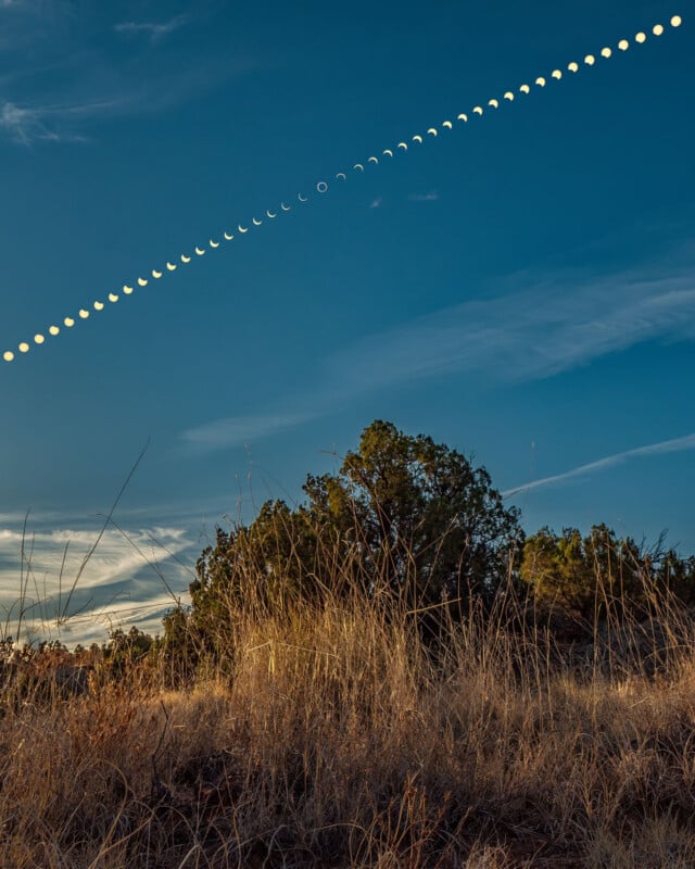 A composite image shows the progression of an annular solar eclipse across a blue sky above a field of dry grass and trees.