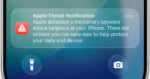 A smartphone screen displays an Apple Threat Notification warning of a mercenary spyware attack on the device.
