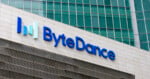 The ByteDance logo is mounted on a light-colored stone wall in front of a modern glass office building.