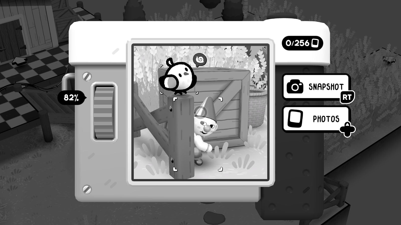 A camera interface displays a black-and-white photograph of a small bird perched on a wooden post next to a garden gnome.