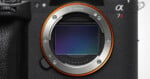 A close-up view of a camera lens mount with a visible sensor, featuring the text 