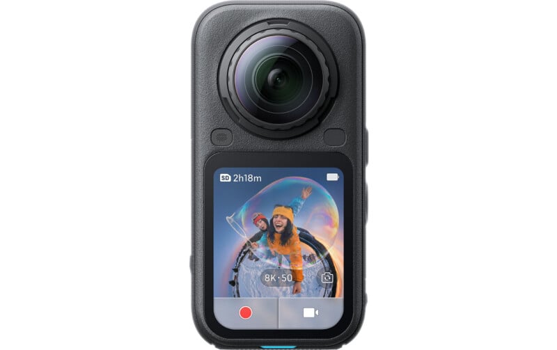 A black 360-degree action camera with a large front-facing lens and a touchscreen display showing a 360-degree photo of two people inside a bubble.