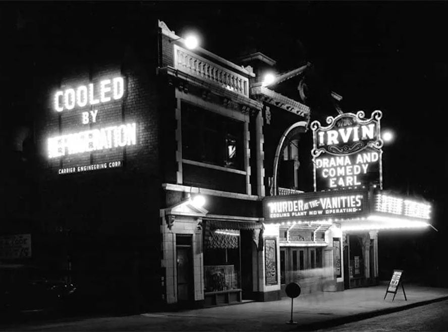 A night view of the Irvin Theatre, featuring a marquee advertising "Murder at the Vanities" and a neon sign reading "Cooled by Refrigeration.