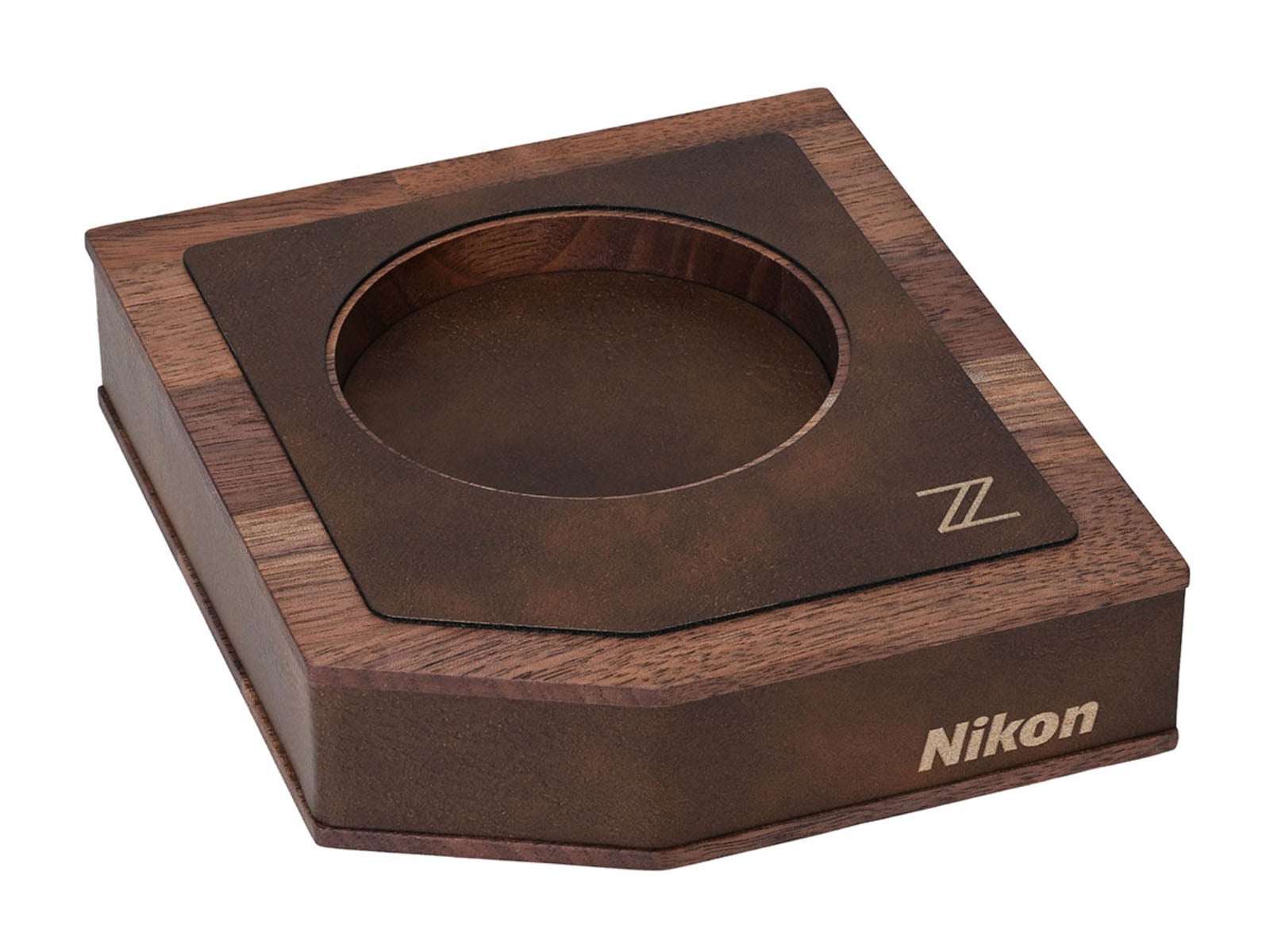 A wooden display stand with a circular cutout, featuring a dark brown textured top plate with a "Z" logo and the "Nikon" brand name printed on the side.