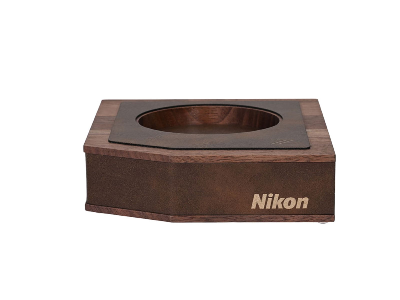 A wooden, hexagonal-shaped display stand with a circular cutout in the center and the word "Nikon" printed on the front side.