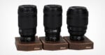 Three Nikon Z-mount lenses, labeled 35mm, 50mm, and 85mm, stand upright on individual wooden display bases against a white background.