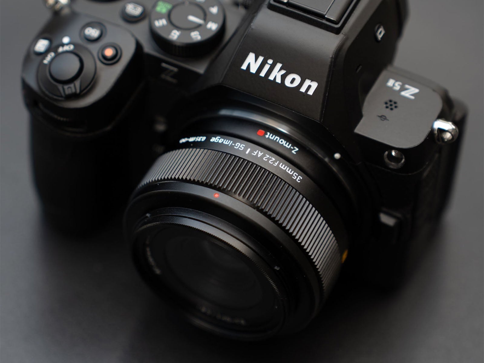 A Nikon Z 5II camera body with a 35mm F2.2 lens attached, viewed from a high angle against a dark background.