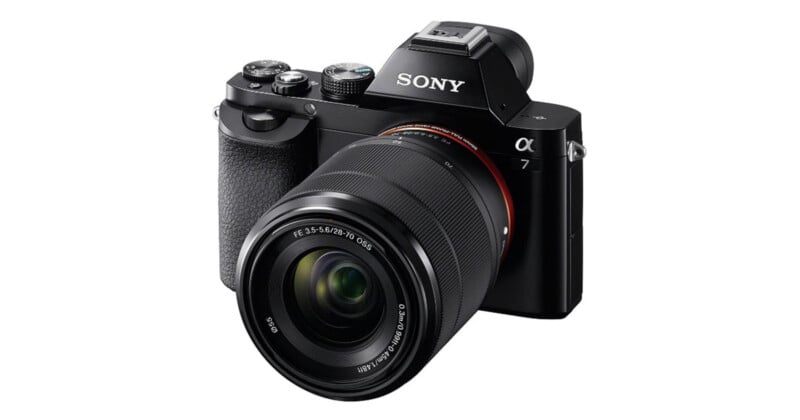 A black Sony Alpha 7 mirrorless camera with a 28-70mm zoom lens attached, viewed from the front-right angle against a white background.