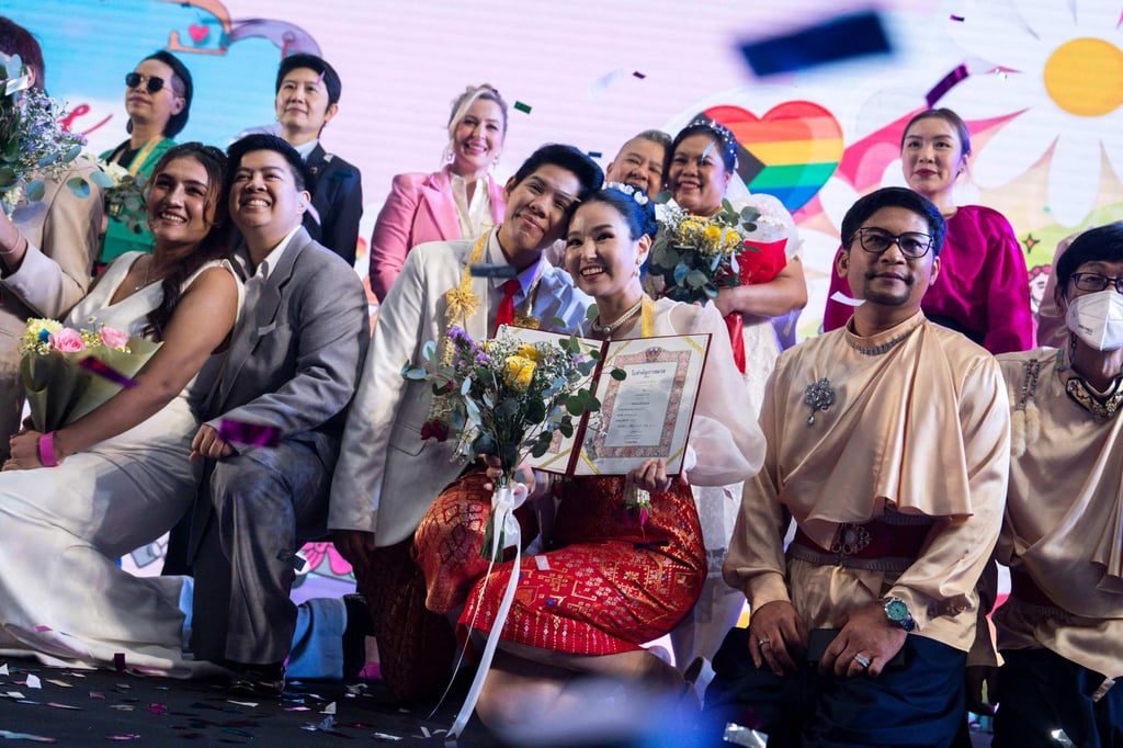A same-sex couple (centre) poses for pictures at a marriage registration event at Paragon shopping mall in Bangkok on Thursday. Photo: AFP