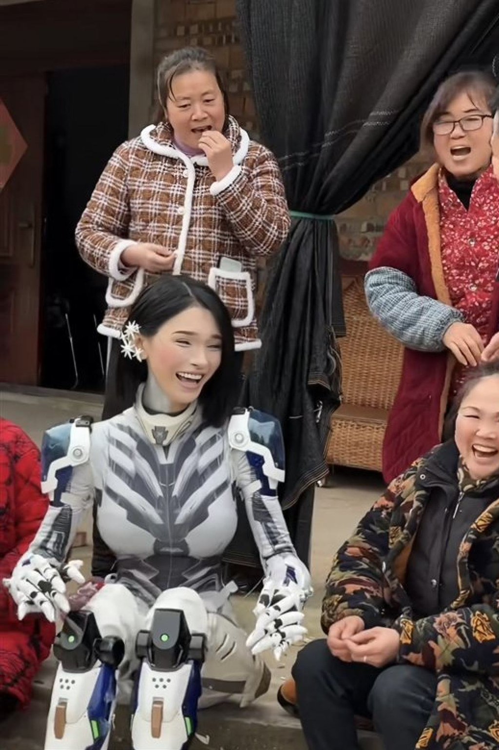 Looking slightly more human, the “robot” laughs and jokes with villagers. Photo: Douyin