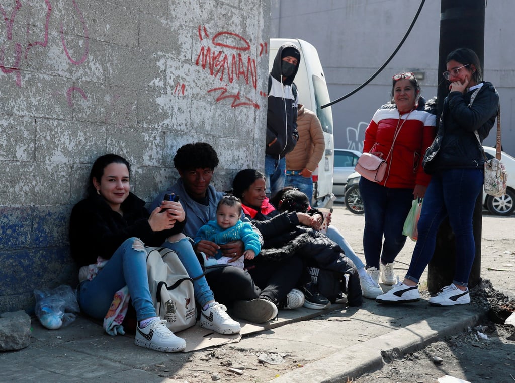 Migrants from Cuba sit on the pavement near the Mexican Commission for Refugee Assistance (COMAR), as they wait to regularise their migratory situation, in Mexico City, Mexico, on Friday. Photo: Reuters