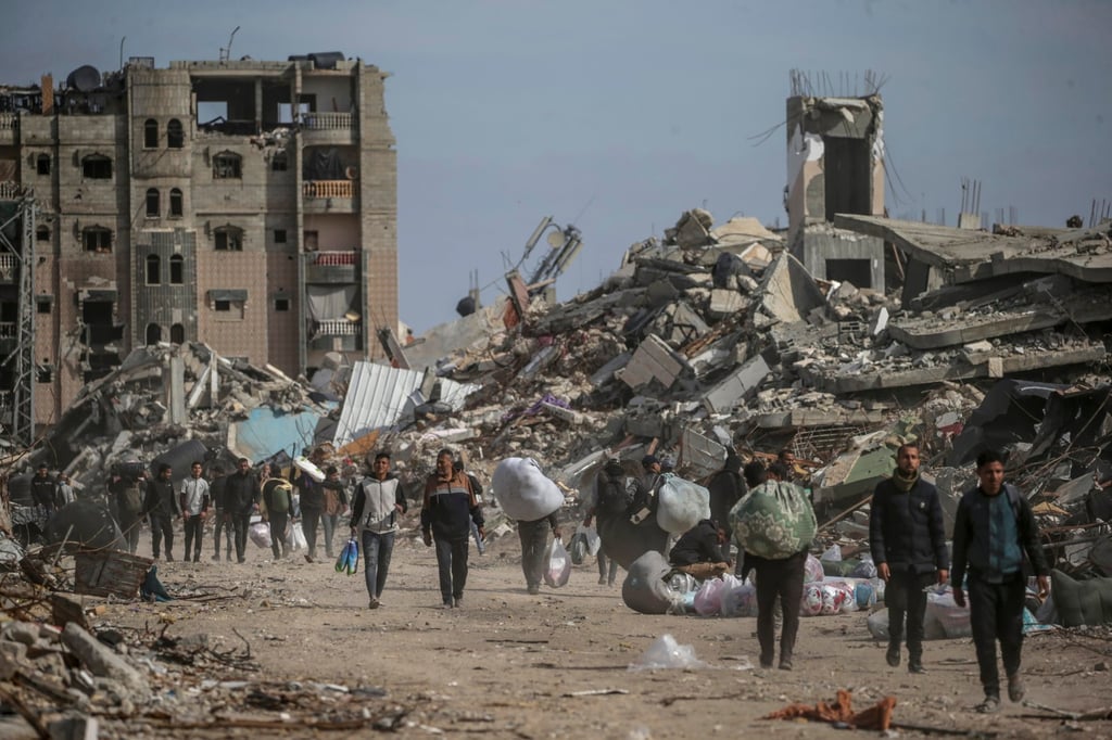 Palestinians walk near destroyed buildings in Rafah, southern Gaza Strip. Photo: EPA-EFE