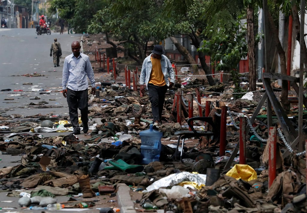 Civilians walk past abandoned military uniforms in Goma. Photo: Reuters