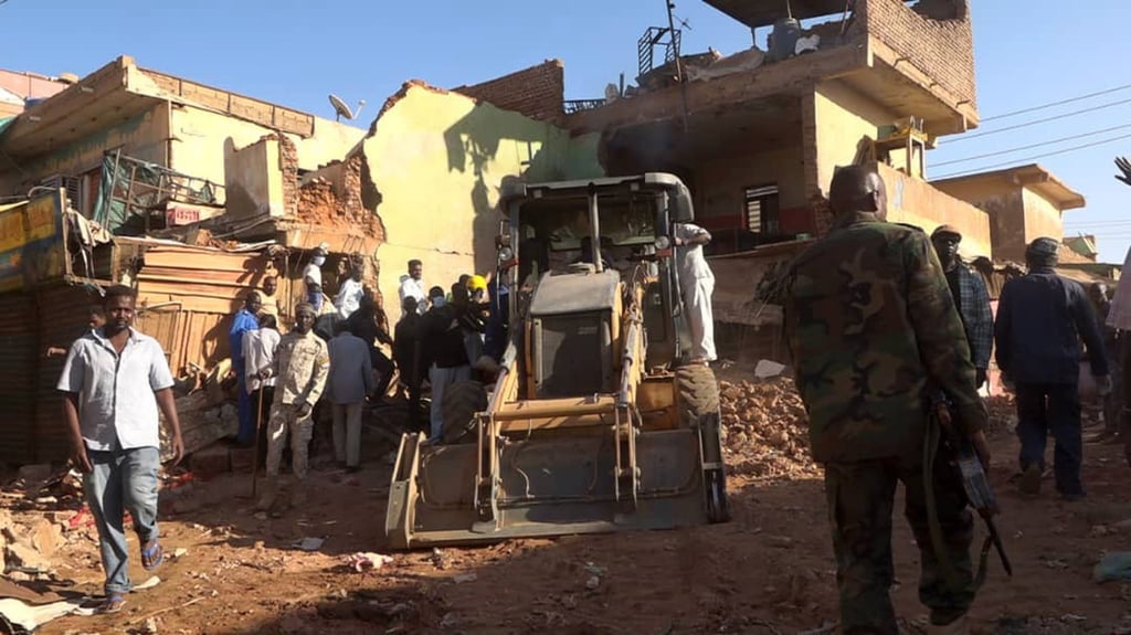 Workers use heavy machinery to remove debris of a building damaged during the attack at Sabrein Market on Saturday. Photo: Khartoum State Press Office/Xinhua