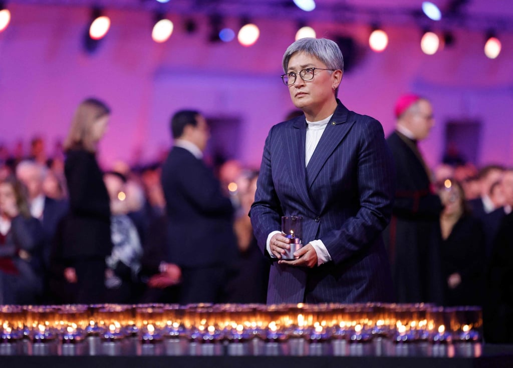 Australian Foreign Minister Penny Wong places a candle to pay tribute to victims at an event in Poland last month commemorating the 80th anniversary of the liberation of Nazi concentration and extermination camps. Photo: AFP