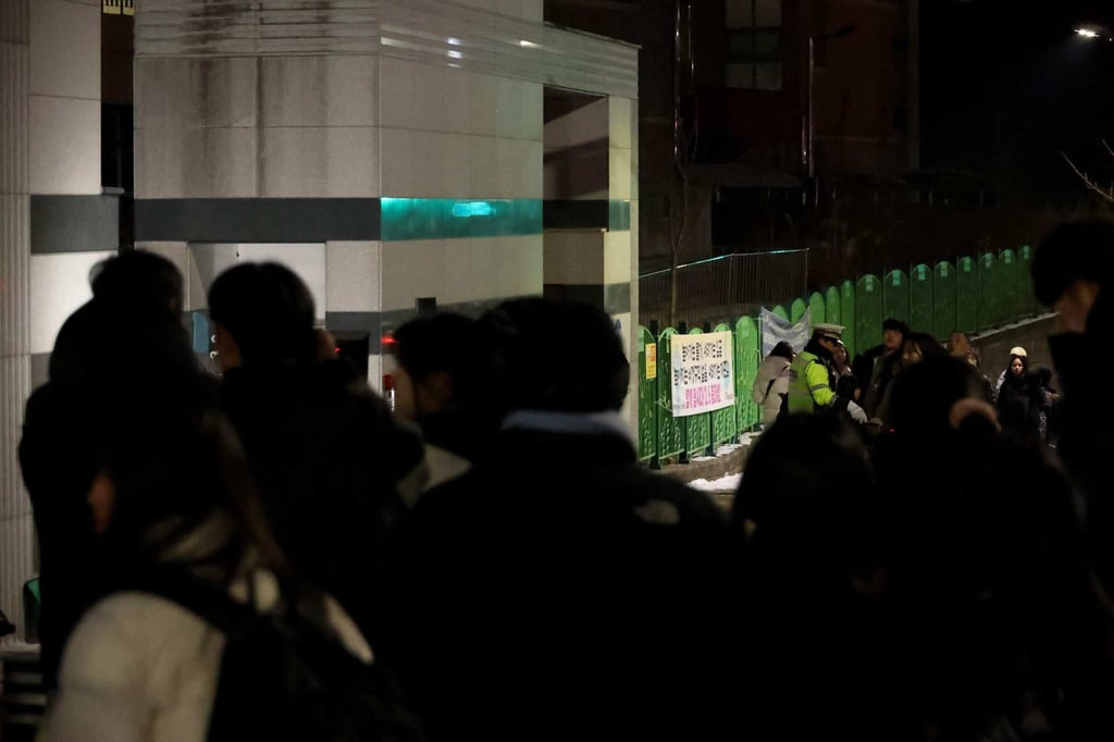 People gather outside the school building in Daejeon on Monday night. Photo: Yonhap/AFP