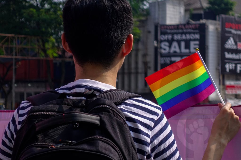 A person hold a rainbow flag at an International Women’s Day march in Kuala Lumpur. Malaysia is perceived as becoming increasingly hostile to LGBTQ expression. Photo: Shutterstock