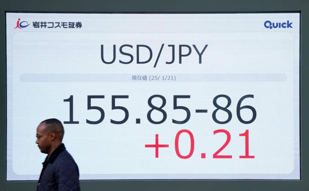 A man walks past an electronic board showing the foreign exchange trading price of the Japanese yen against the US dollar on a street in central Tokyo on January 21. Photo: AFP