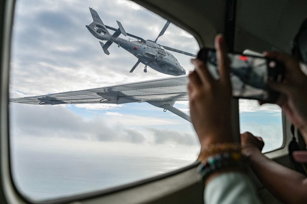 An aircraft identified by the Philippine Coast Guard as a Chinese navy helicopter (left) flies near a Bureau of Fisheries and Aquatic Resources plane during an aerial reconnaissance flight at Scarborough Shoal in the South China Sea on Tuesday. Photo: AFP