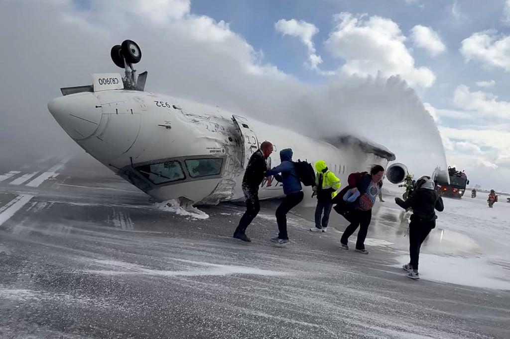 Passengers exiting the crashed jet on Monday. Photo: Peter Koukov via Reuters