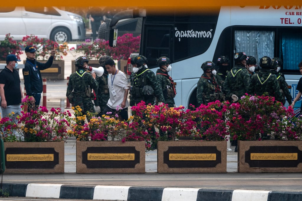A man escorted by Thai soldiers ahead of flight to China. Photo: Khu Sam