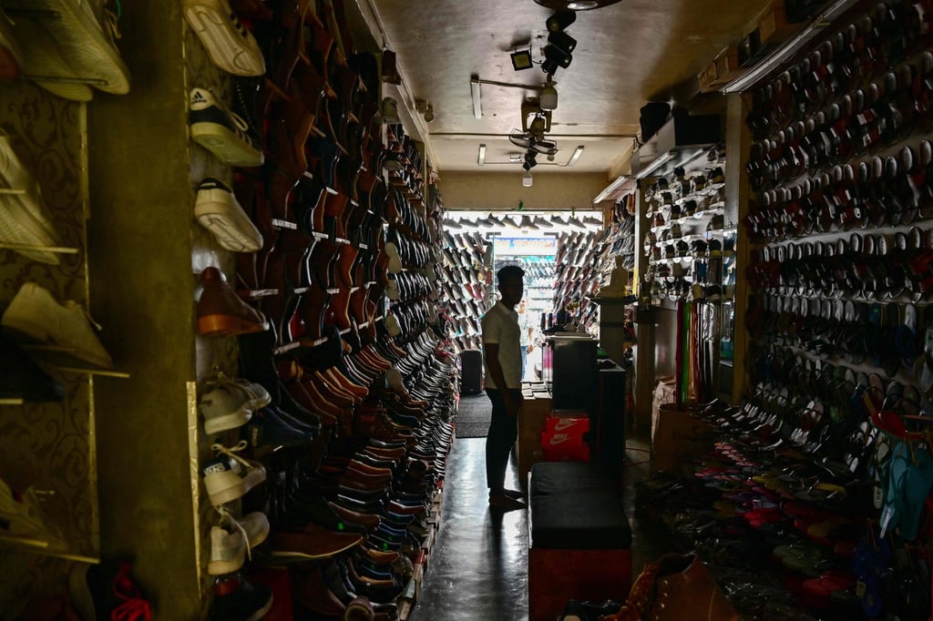 A man waits for customers at a dimmed footwear shop during a nationwide power outage in Galle, Sri Lanka, on February 9. Photo: AFP