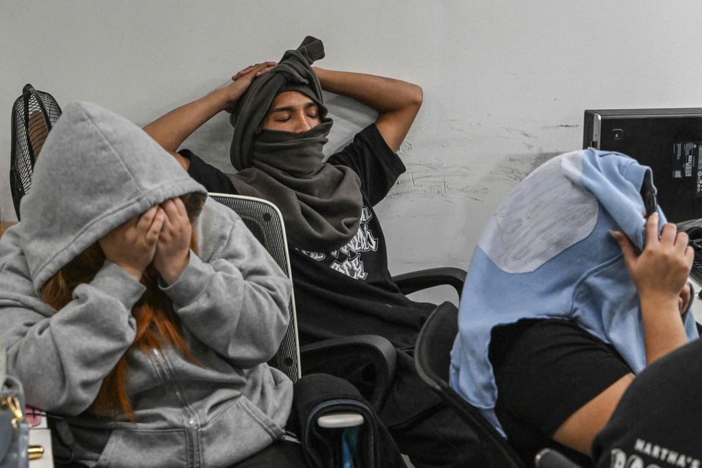 Workers during a raid by agents of the Presidential Anti-Organised Crime Commission (PAOCC) and the National Bureau of Investigation at an office of a suspected online scam farm in Manila on January 31. Photo: AFP