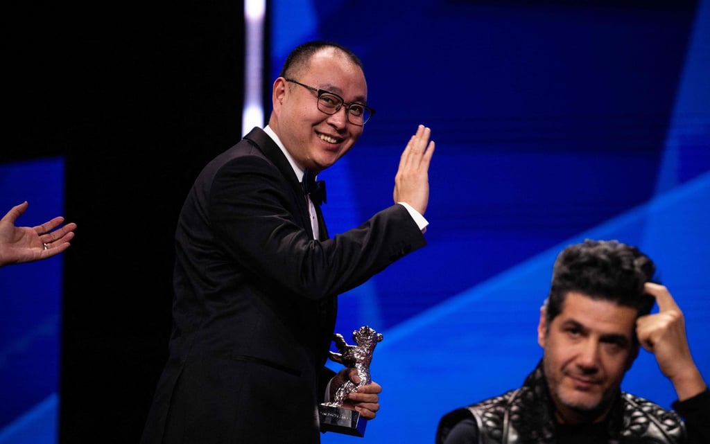 Chinese film director Huo Meng waves to the audience as he leaves the stage after being awarded the Silver Bear for best director for his film Living the Land in Berlin. Photo: AFP