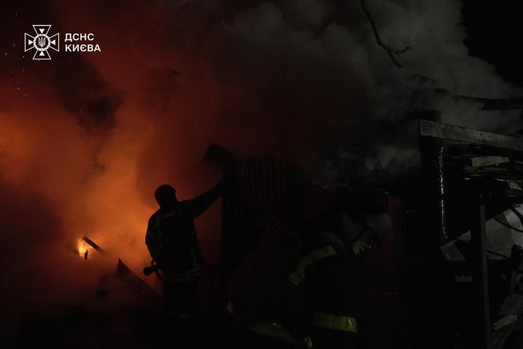 Firefighters in Kyiv, Ukraine, work to extinguish a fire on Sunday following an attack by Russia. Photo: Handout via AFP