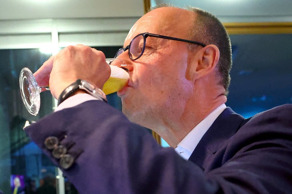 Friedrich Merz drinks beer after the exit poll results are announced. Photo: Reuters