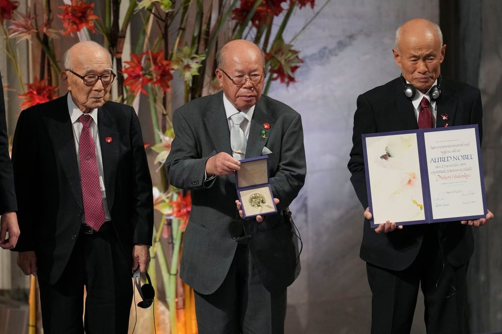 (From left) Terumi Tanaka, Shigemitsu Tanaka and Toshiyuki Mimaki, representatives of the Nobel Peace Prize winner Nihon Hidankyo, hold the award during a ceremony in Oslo, Norway, on December 10, 2024. Photo: AP