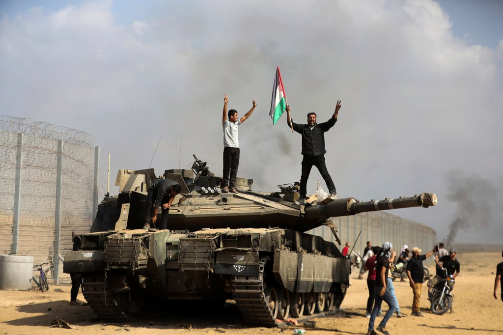Palestinians celebrate by a captured Israeli tank at the southern Gaza Strip fence east of Khan Younis on October 7, 2023. File photo: AP
