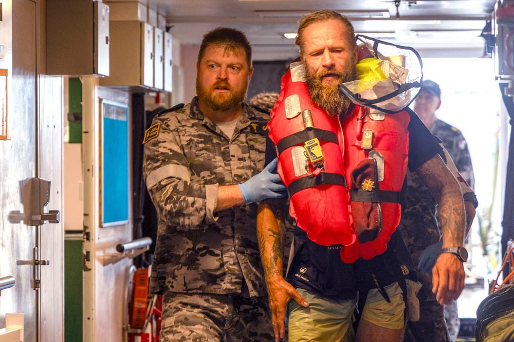 Chief Petty Officer Medic Peter Gough (left) assisting Lithuanian long-distance rower Aurimas Mockus aboard the Royal Australian Navy ship HMAS Choules. Photo: AFP