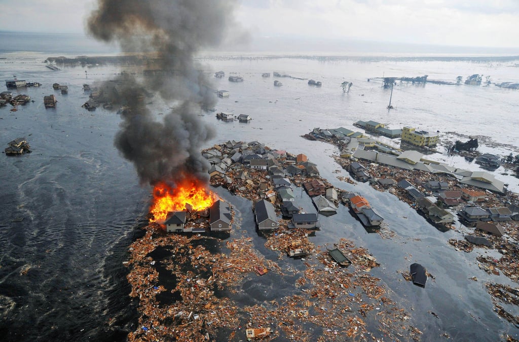 Houses swallowed by a tsunami burn in Sendai, Miyagi prefecture, on March 11, 2011 after a huge earthquake struck off Japan’s northeastern coast. Photo: Kyodo/AP