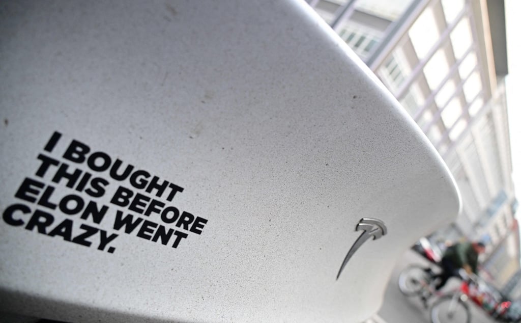 A sticker reading “I bought this before Elon went crazy” is seen on a Tesla electric car at a charging station in Berlin, Germany, last month. Photo: AFP