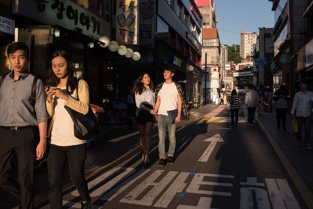 Couples walk along a street in the Sinchon area of Seoul. Photo: AFP
