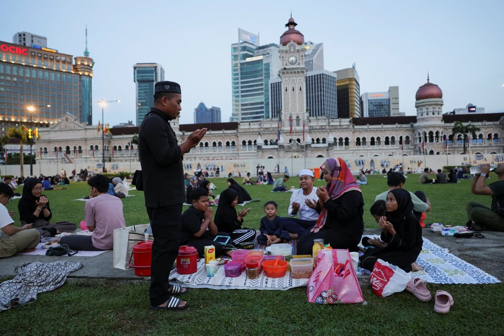 A Muslim family recites prayers before they break their fast during Ramadan in Kuala Lumpur on March 2. Photo: Reuters